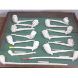 A collection of named clay pipes in wooden display case, including Victorian
