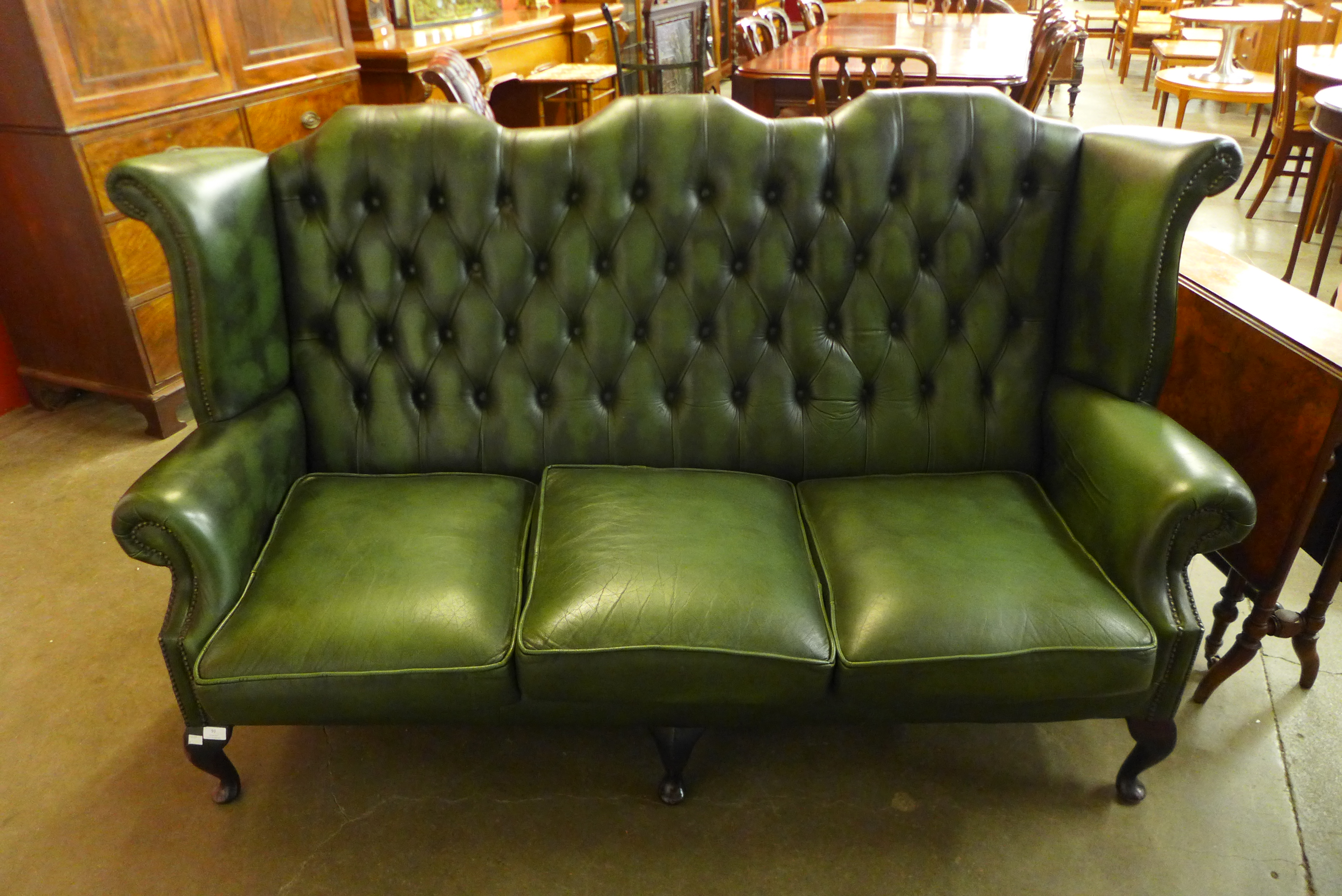 A green leather Chesterfield wingback settee