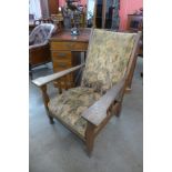 An Arts and Crafts oak upholstered armchair