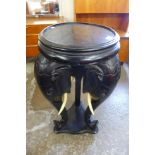 A carved ebonised elephant jardiniere stand