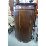 A George III inlaid mahgoany bow front hanging corner cupboard