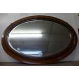 A mahogany oval framed mirror
