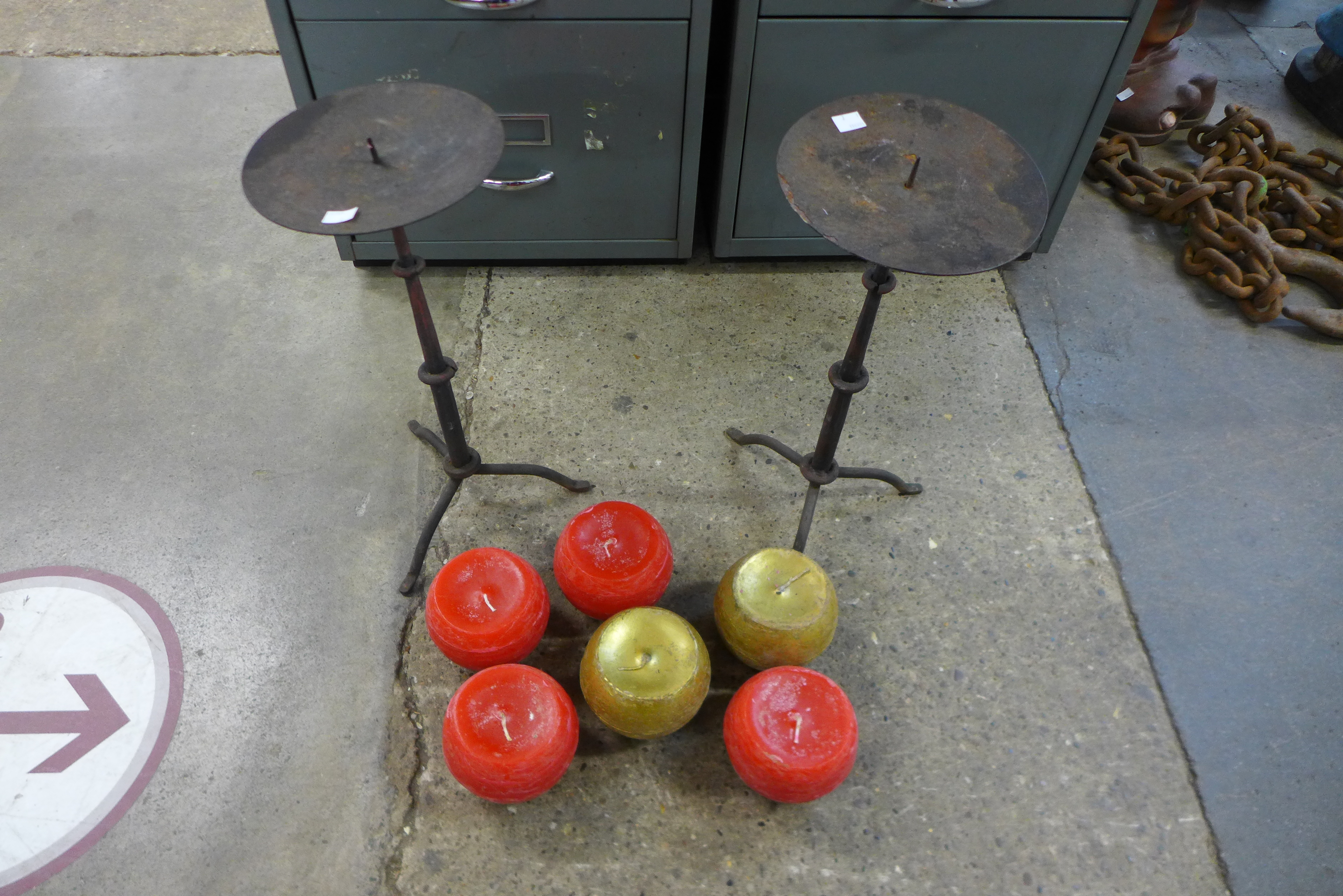 A pair of steel Gothic style candle stands and candles