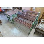 A pair of cast iron garden benches and matching table