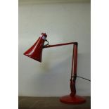 A red metal anglepoise desk lamp