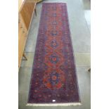 A red ground runner rug, 296 x 85cms