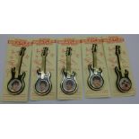 A set of five Beatles Invicta Plastics guitar brooches on backing cards