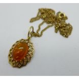 A yellow metal and amber pendant on a 9ct gold chain, chain 4.4g, pendant 2.7g