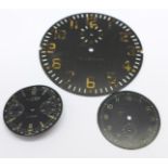 Two black wristwatch dials and a cockpit clock dial
