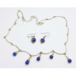 A silver and blue stone necklace and earrings