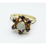 A yellow metal dark sapphire and opal cluster ring, with control marks on the outside of the