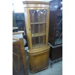 A walnut freestanding corner cabinet