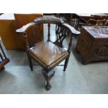 A George III style carved oak corner chair