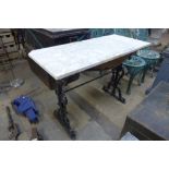 A cast iron and marble topped garden table