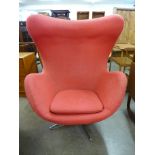 An Arne Jacobsen style chrome and red fabric upholstered egg chair
