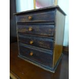 An early 20th Century canary wood table top four drawer chest, made by Henry Stone & Son, 36cms h,