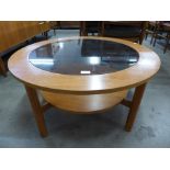 A teak and glass topped circular coffee table