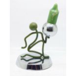 An unusual Art Deco chromium plated and bronze candlestick, the green patinated bronze kneeling