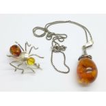 A silver and amber pendant and chain, and a silver spider brooch