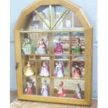 Twelve miniature Royal Doulton figures in a display case