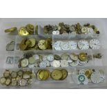 A collection of watch movements, dials and lady's wristwatch heads