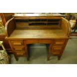 An early 20th Century oak tambour roll top desk