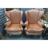 A pair of 1930's Queen Anne style walnut and upholstered wingback armchairs