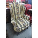 A 1930's Queen Anne style mahogany and upholstered wingback armchair