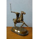 A bronze figure of a polo player on horseback, on black marble plinth