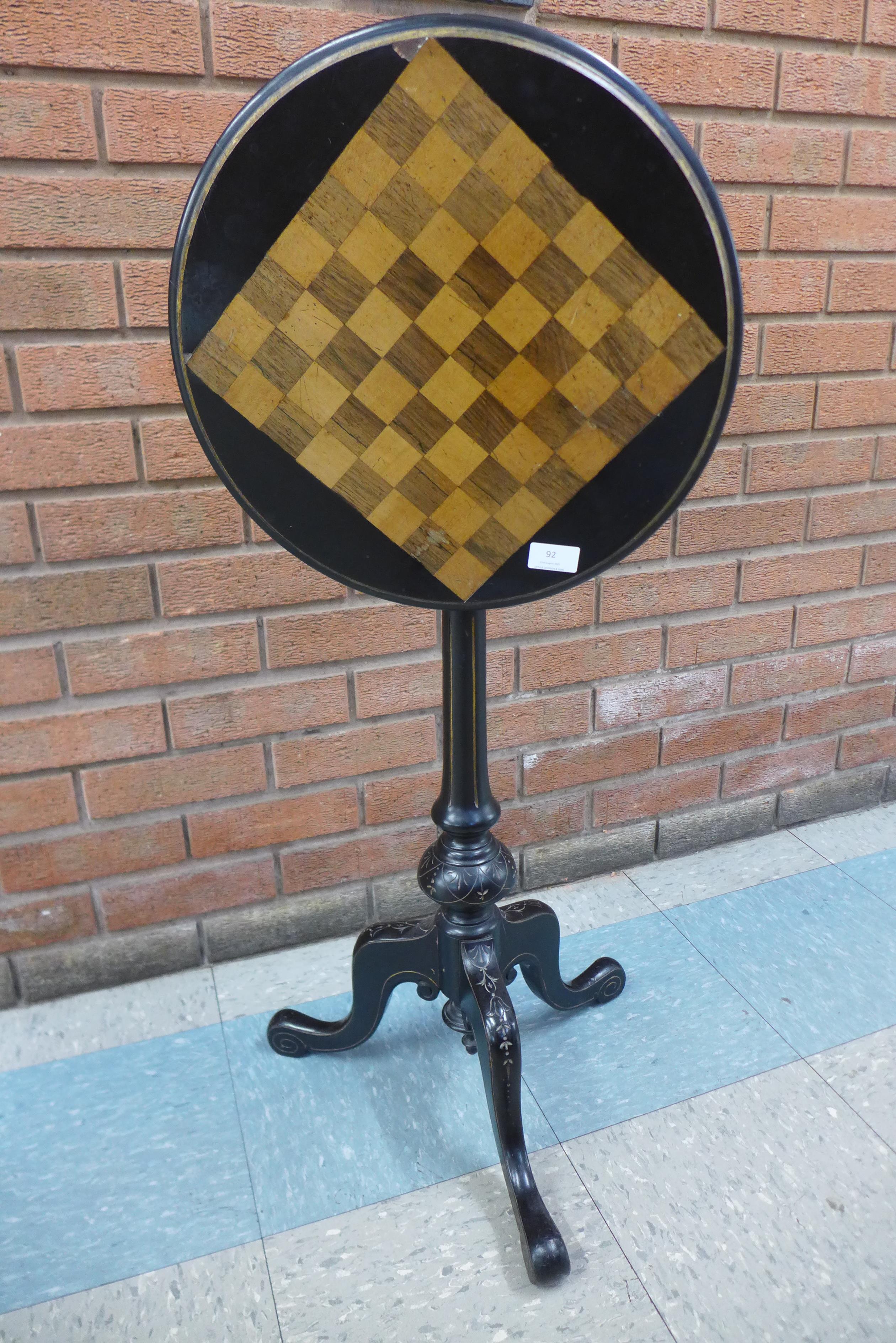 A Victorian Aesthetic Movement ebonised circular tilt-top games table