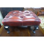 A mahogany and red leather buttoned footstool