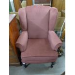 A mahogany and upholstered wingback armchair