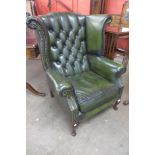 A beech and green leather Chesterfield wingback armchair