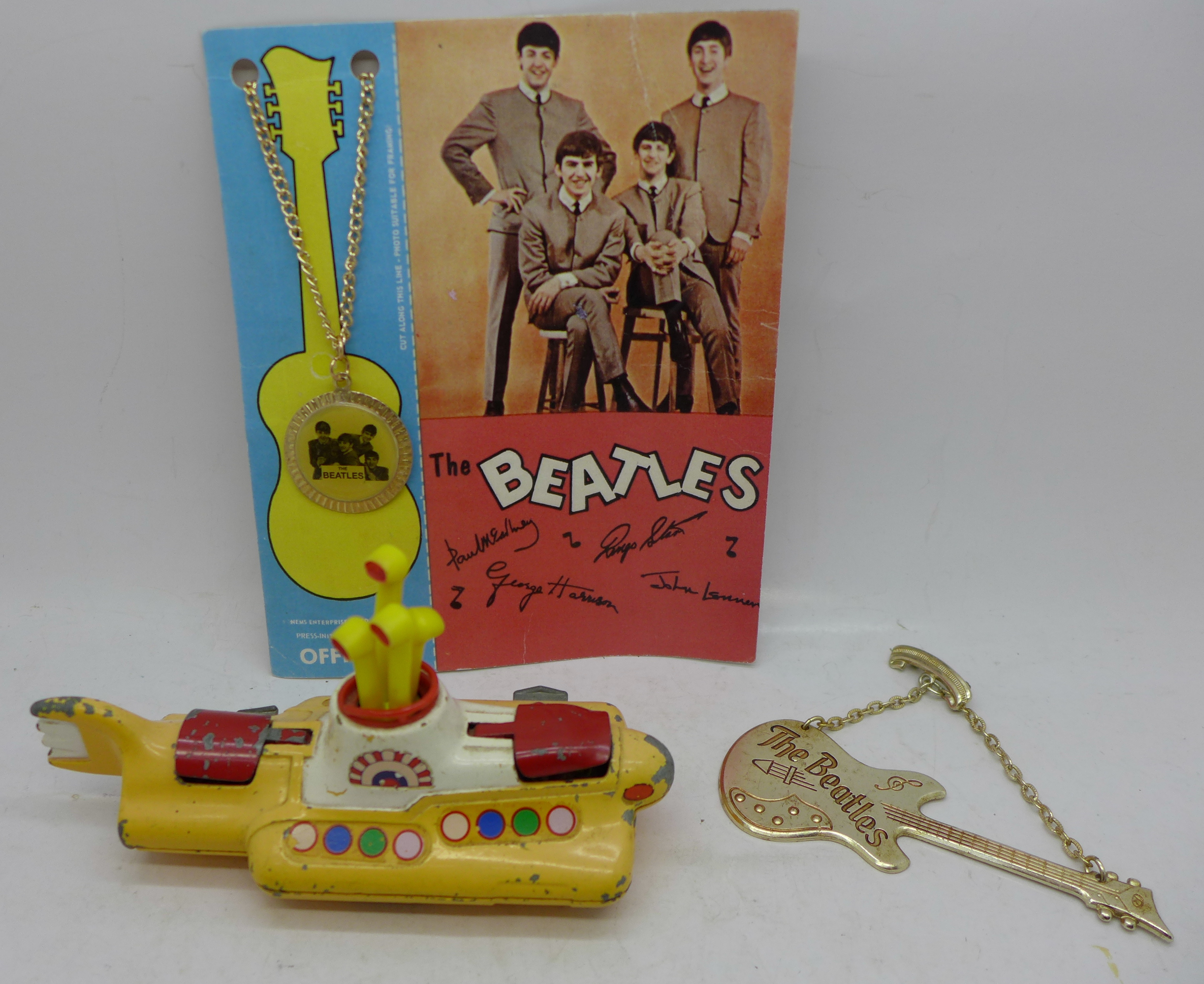 Beatles collection; necklace on back card, guitar brooch and Corgi Toys Yellow Submarine, (playworn)