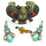 A modern Egyptian Revival bangle and a pair of earrings, and an eagle badge