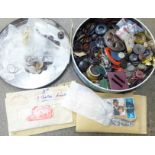 A tin of buttons and loose stamps