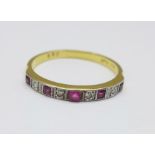 An 18ct gold, platinum set ruby and diamond nine stone ring, centre stone replaced, 2.8g, P