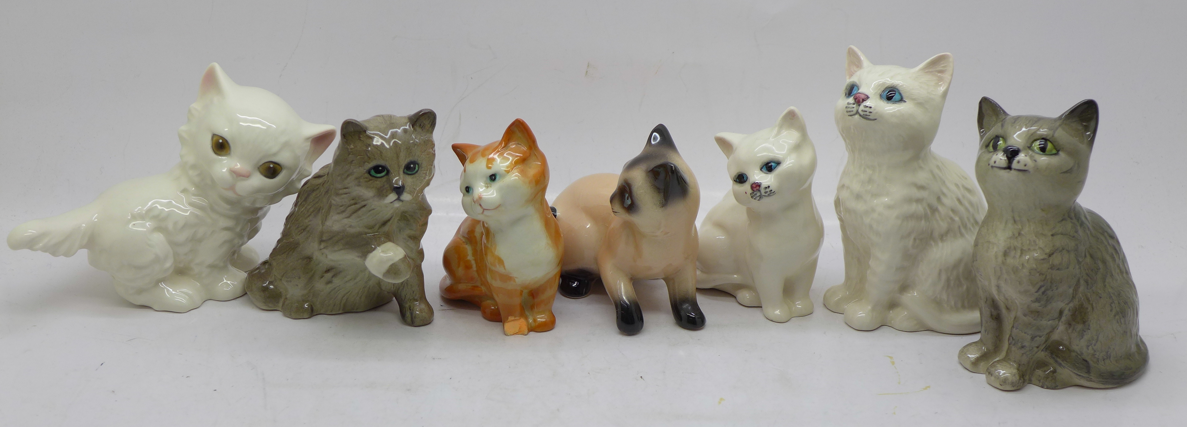 Seven cat figures, three Royal Doulton, two Beswick, one a/f, and two Goebel