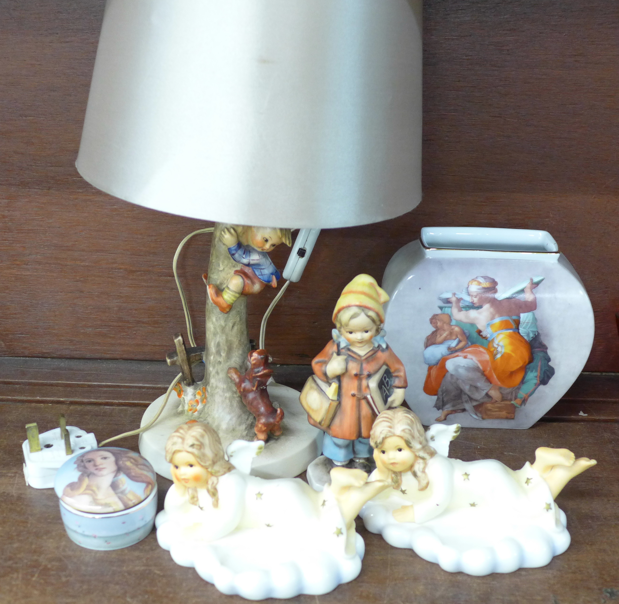 A Hummel table lamp, two Hummel figures, a Goebel pot, a figure made in West Germany, one a/f, and a