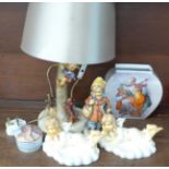A Hummel table lamp, two Hummel figures, a Goebel pot, a figure made in West Germany, one a/f, and a