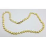 A faux pearl necklace with 9ct gold clasp