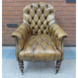 A George IV brass nailed green buttoned leather library chair, on turned mahogany legs and brass