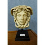A faux marble bust of Medusa, on ebonised socle