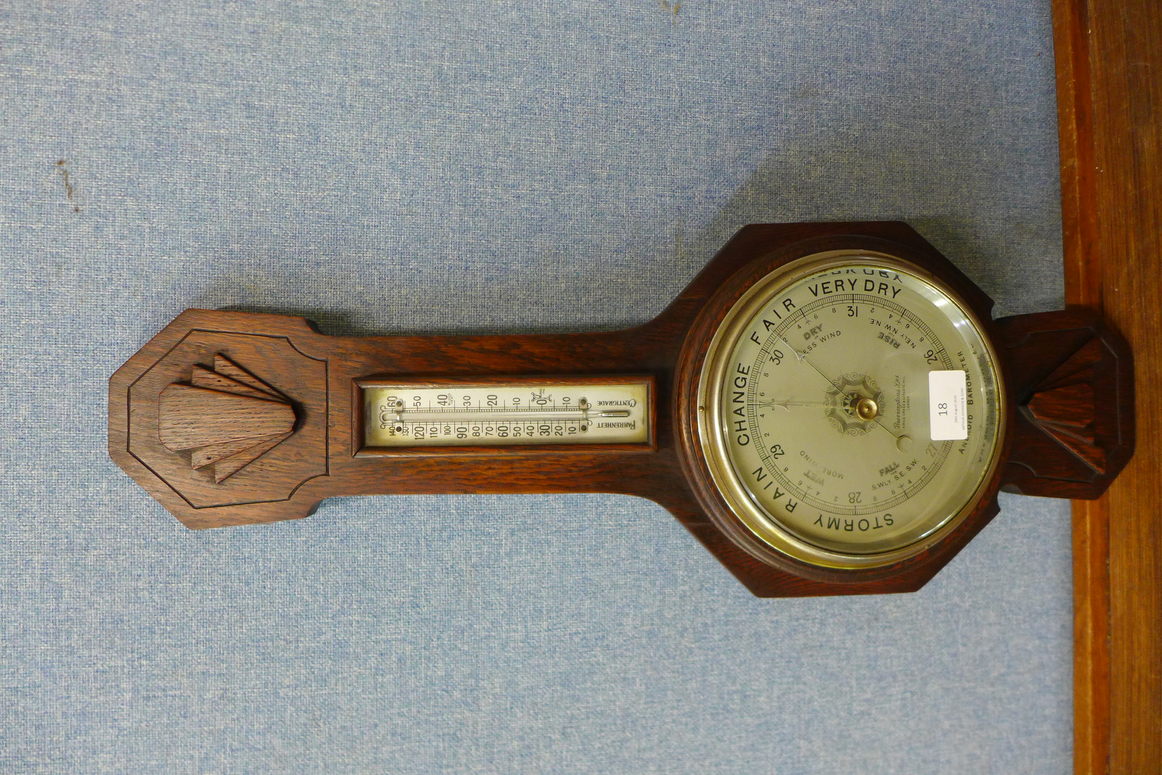 An Art Deco Bravingtons Ltd. carved oak aneroid barometer