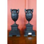 A pair of bronze Greek Revival urns, on black marbles socles, 35cms h