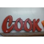 A painted metal cook sign