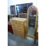 A pine cheval mirror and a pine chest of drawers