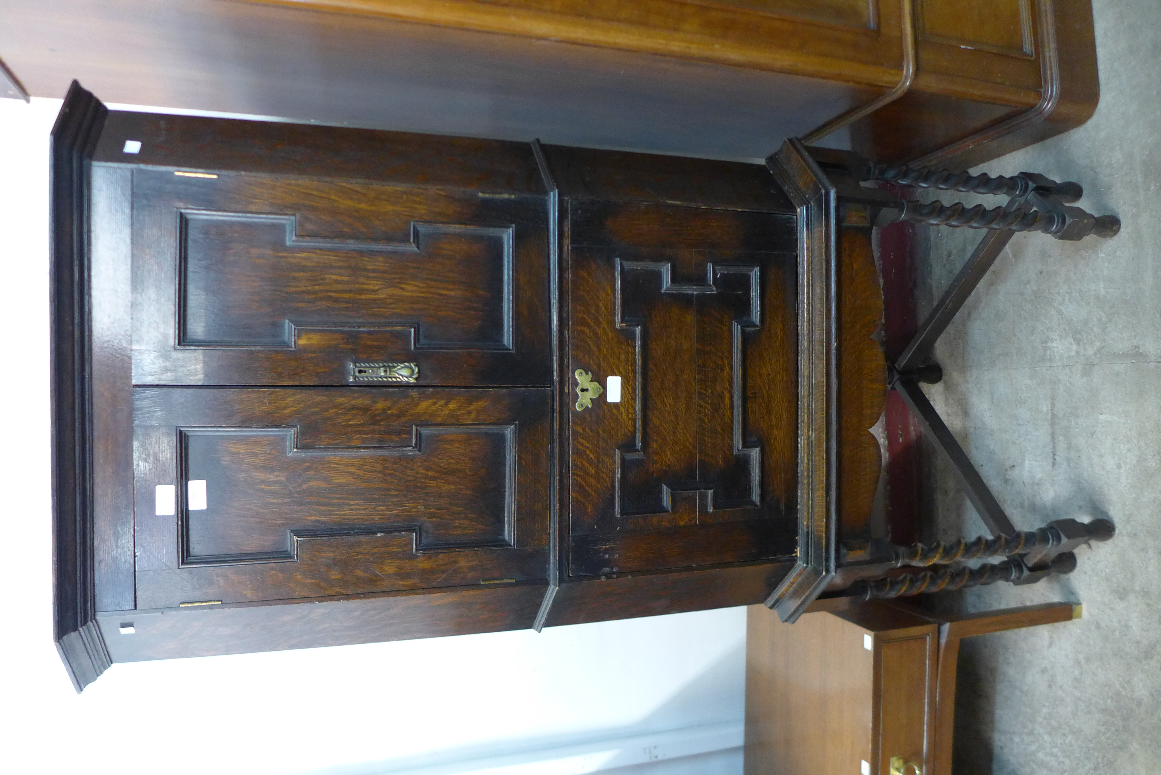 A Jacobean Revival oak geometric moulded corner cupboard on stand