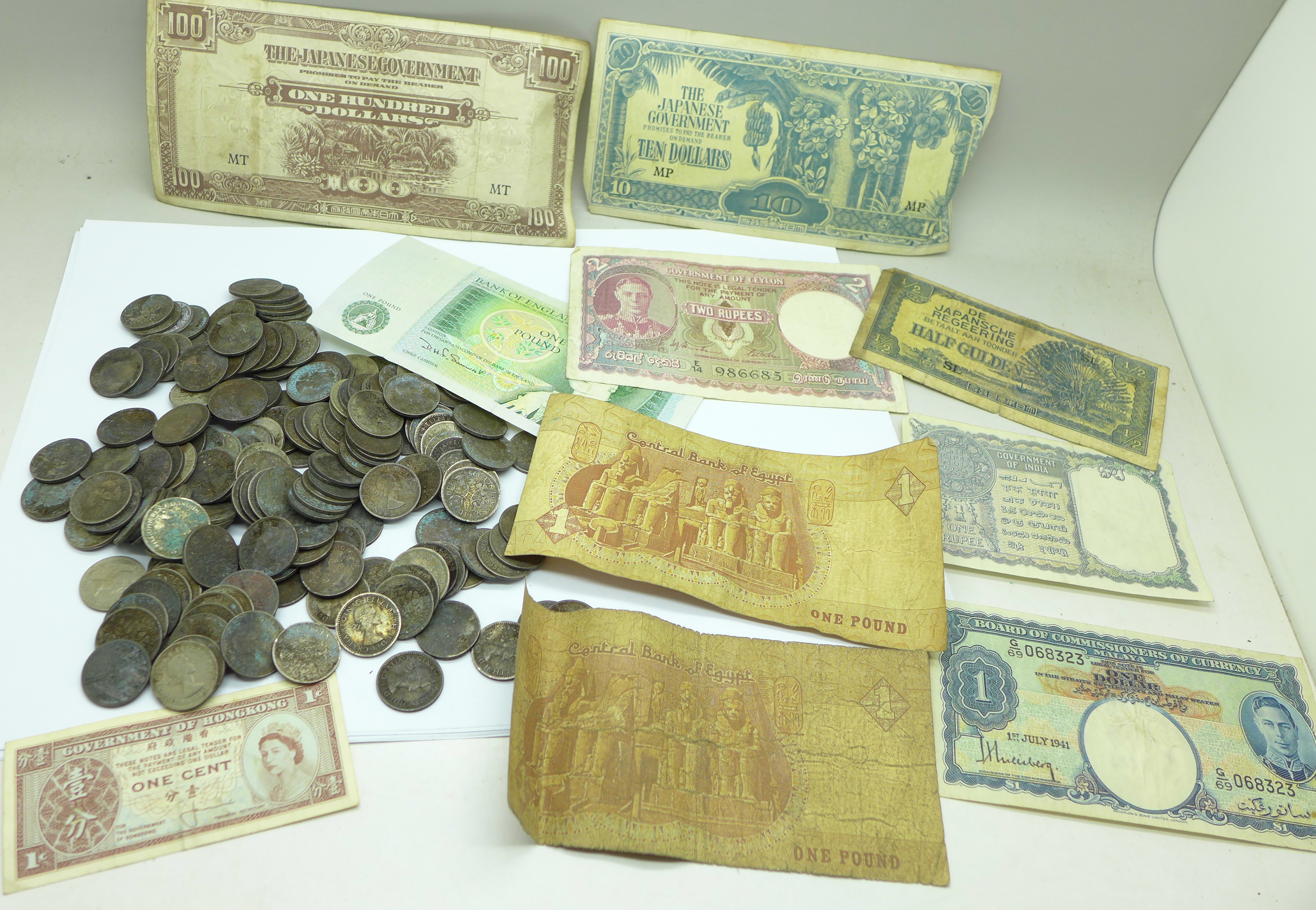 A collection of sixpences and foreign banknotes