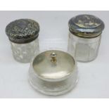 Three silver topped glass jars, (one lid a/f, perforated, shallow glass jar a/f and lid dented)